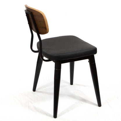 A modern dining chair with a black upholstered seat, black metal frame and legs, and a curved backrest featuring a natural wood inlay on a white background.