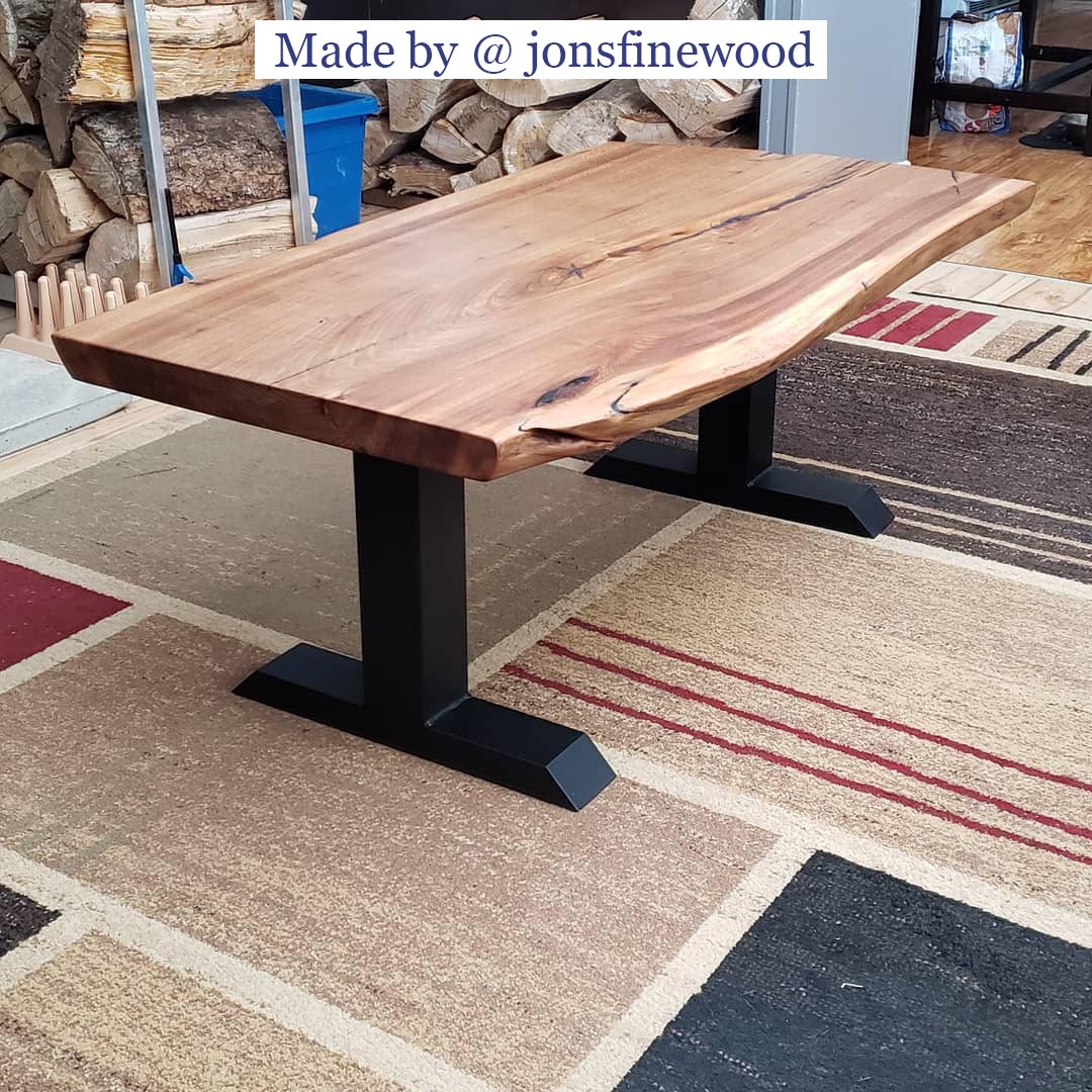 live edge coffee table supported by black T-shaped metal base