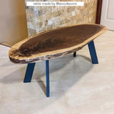 an oval coffee table with 4 black metal legs